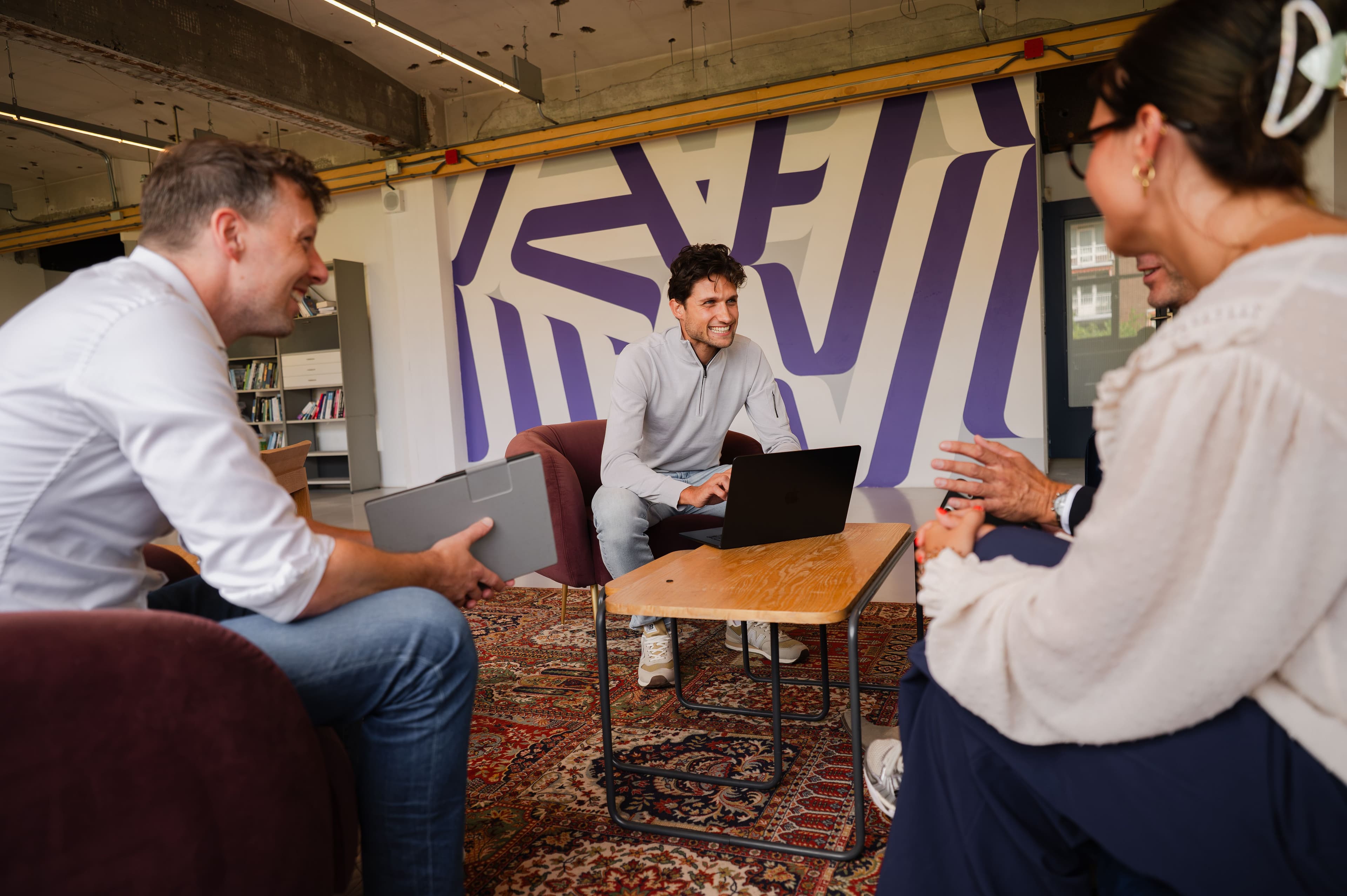 Team DriePuntNul in gesprek op kantoor